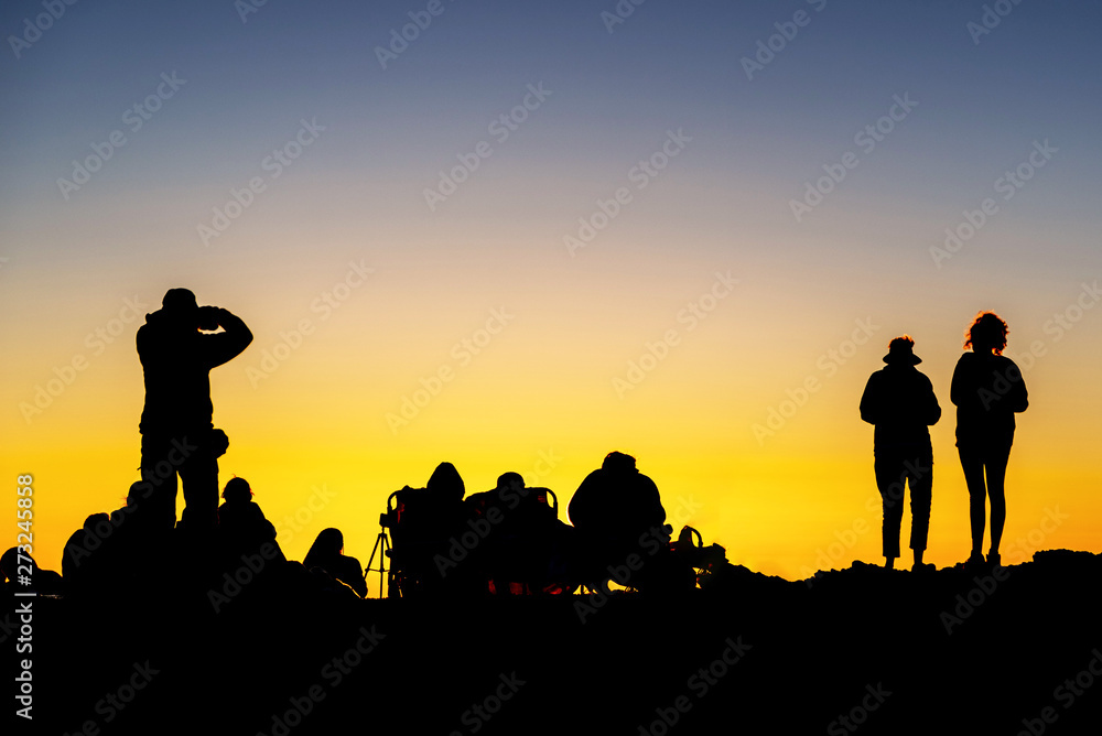 Silhouette of crowd enjoying the sunset atop Mount Haleakala on Maui, Hawaii