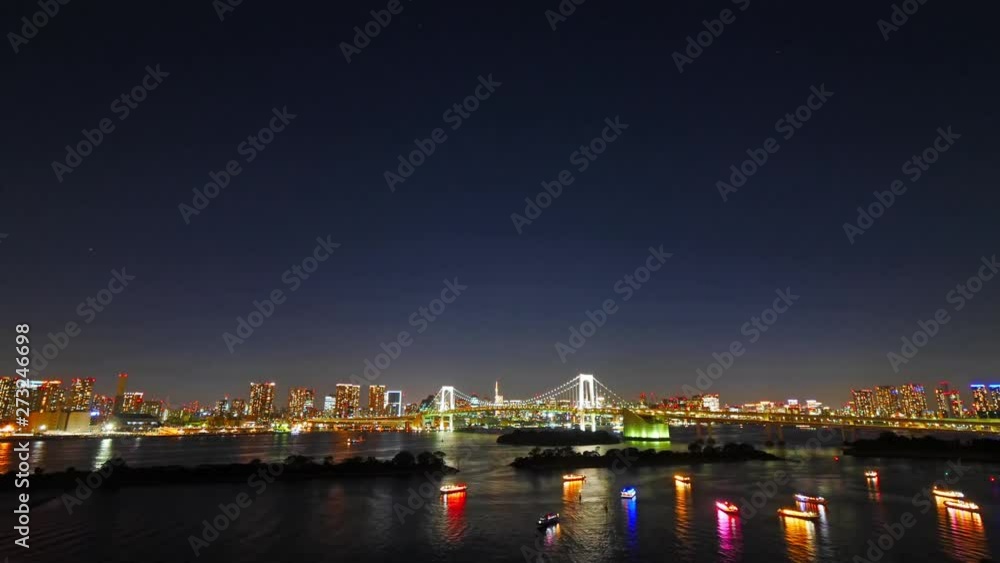 Illuminated Rainbow Bridge and colorful boats in Tokyo, Japan Illuminated Rainbow Bridge and colorful boats in Tokyo, Japan