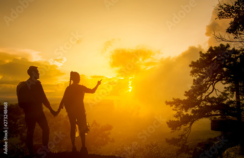 Silhouette couple on the cliff at sunset
