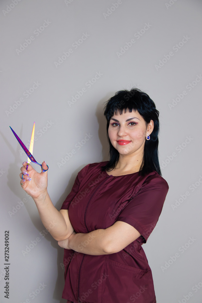 Woman in a suit with scissors on a monochrome gray background. Woman with scissors. Woman in a suit. Woman in a suit with scissors on a monochrome gray background. Woman with scissors. Woman in a suit.