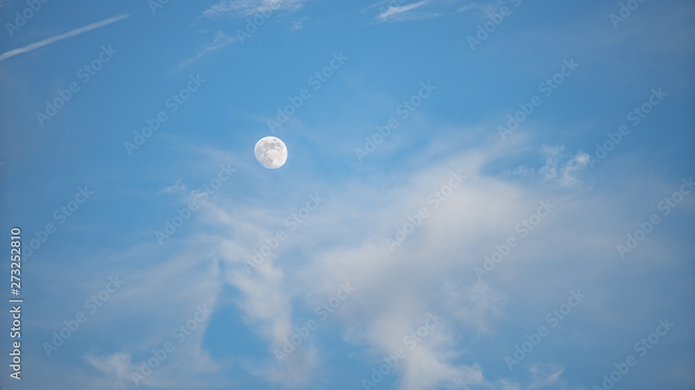 moon is visible in a vibrant blue sky moon is visible in a vibrant blue sky