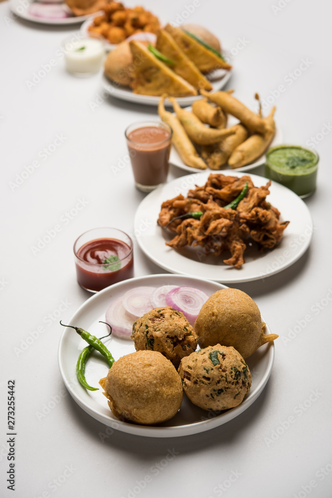 Indian Tea time snacks in group includes Veg Samosa, Kachori/kachaudi, aloo bonda, khaman dhokla, bread, onion,chilli and moong pakora/pakoda/bhaji/bhajji/Bhajiya/bajji with sauces, selective focus Indian Tea time snacks in group includes Veg Samosa, Kachori/kachaudi, aloo bonda, khaman dhokla, bread, onion,chilli and moong pakora/pakoda/bhaji/bhajji/Bhajiya/bajji with sauces, selective focus