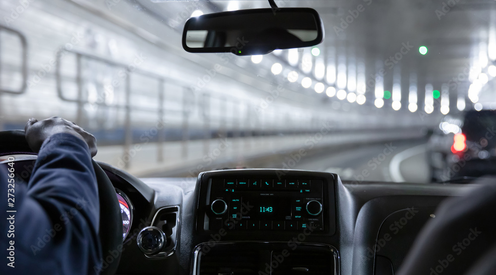 Driving in Lincoln tunnel, New York. Close up view on cab driver hand and dashboard