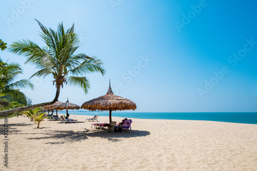Beach chairs, umbrella and palms on sandy beach near sea. island in Phuket, Thailand. Travel inspirational, Summer holiday and vacation concept for tourism relaxing. © jakkapan