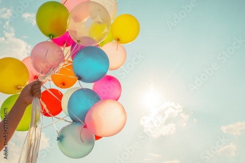 Fototapeta Ręka trzyma wielo- barwionych balony robić z retro rocznika instagram filtra efektem.