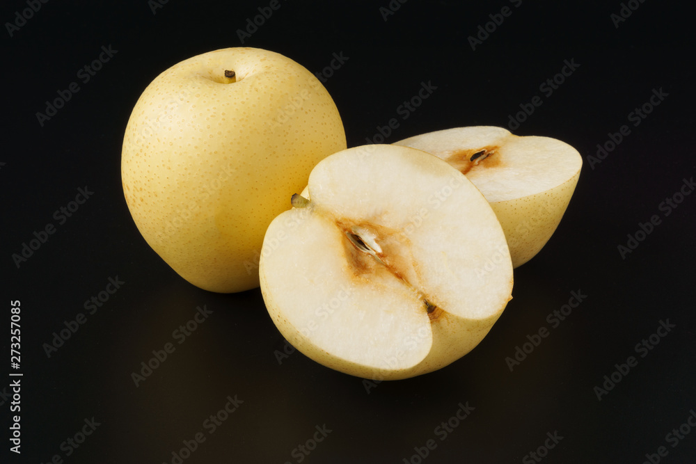Sand pear full and half fruit isolated on black background