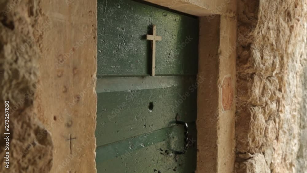 Atmospheric religious places of Montenegro. Cross on the door of the old monastery in Perast. Atmospheric religious places of Montenegro. Cross on the door of the old monastery in Perast.
