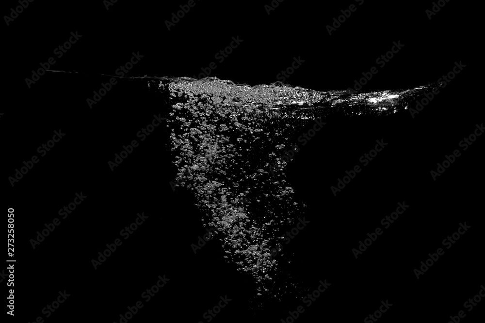 Many bubbles under the water surface, completely black background.