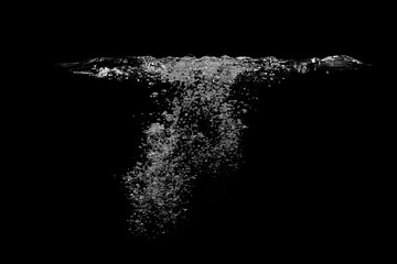 Many bubbles under the water surface, completely black background.