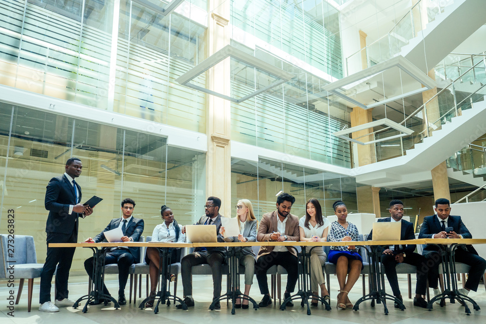 a group of successful afro americans, europeans ,arabic and korean businessman and businesswoman working in the office with large glass windows a group of successful afro americans, europeans ,arabic and korean businessman and businesswoman working in the office with large glass windows