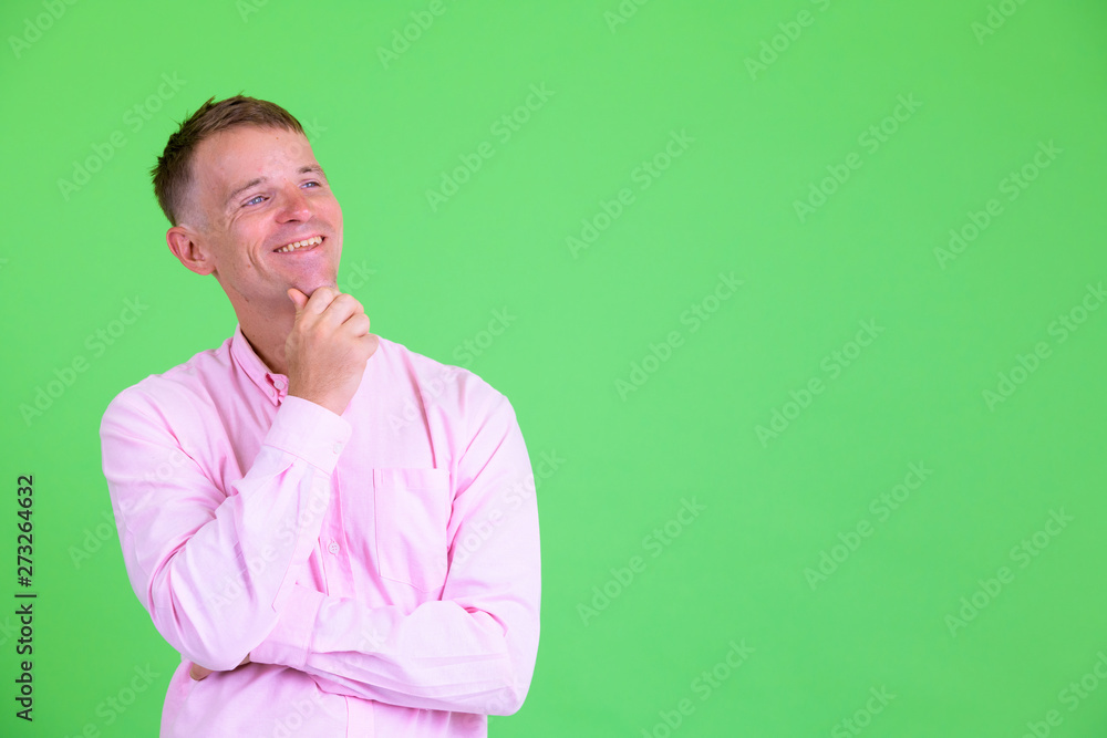 Studio shot of happy businessman thinking and looking up Studio shot of happy businessman thinking and looking up