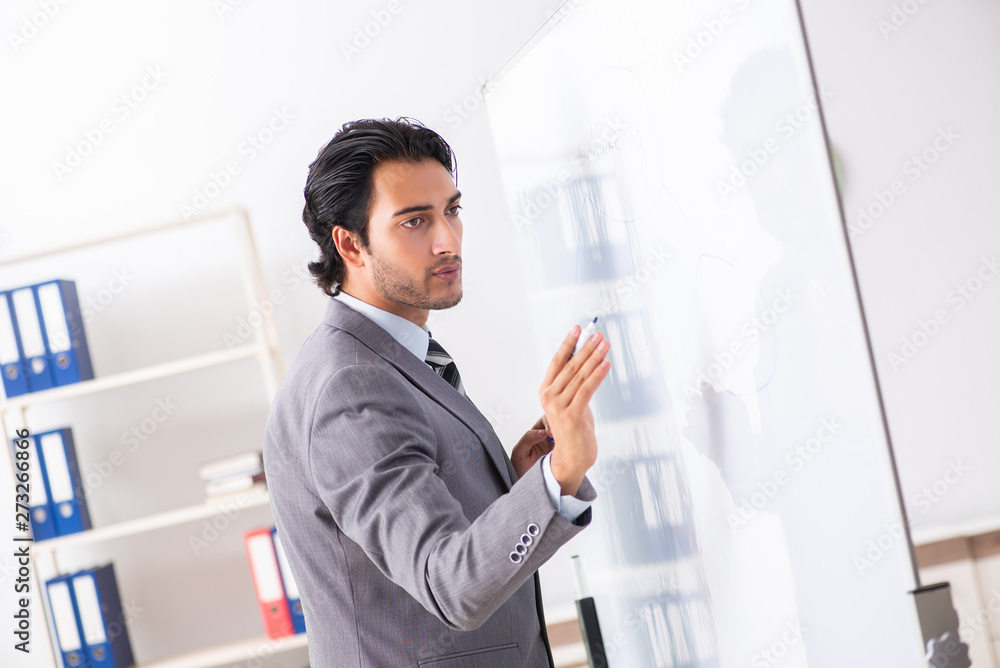 Young handsome businessman in front of whiteboard Young handsome businessman in front of whiteboard