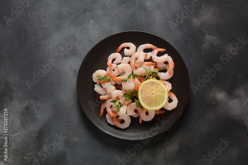 Fresh prawns. Raw shrimps, prawns in a plate on a dark background. Seafood. 