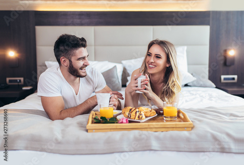 Romantic happy couple having breakfast in bed