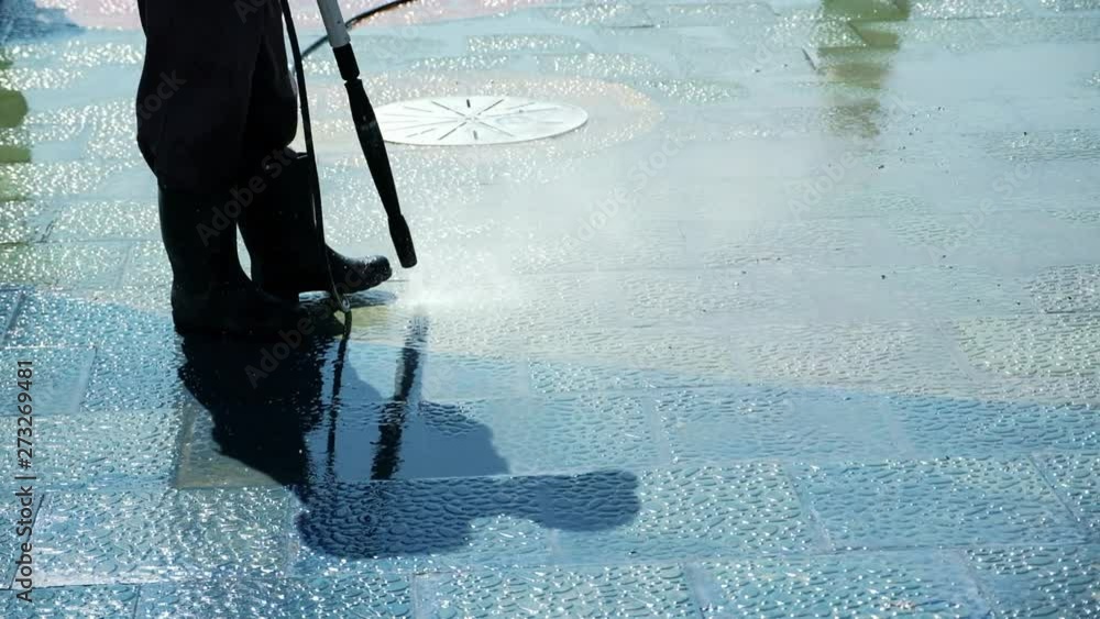 Street sweeper cleaning asphalt. Cleaning city streets with water hose