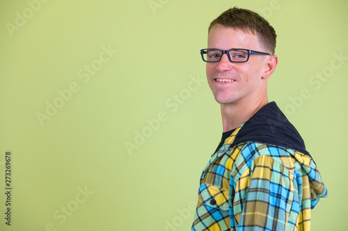 Closeup profile view of happy nerd man with eyeglasses smiling and looking at camera