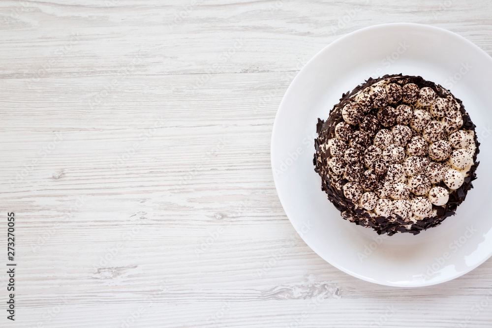 Homemade tiramisu cake on a white plate on a white wooden surface, top view. Flat lay, overhead, from above. Copy space. Homemade tiramisu cake on a white plate on a white wooden surface, top view. Flat lay, overhead, from above. Copy space.