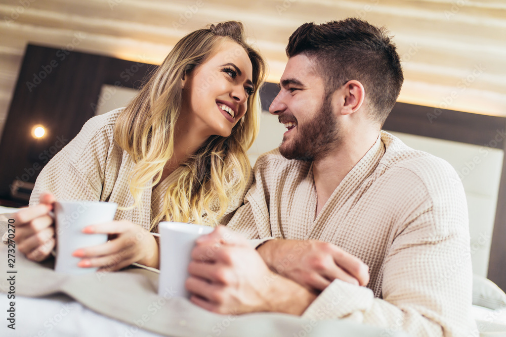 Young happy couple drink coffee in luxury hotel room. Young happy couple drink coffee in luxury hotel room.