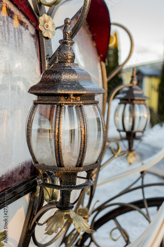 Two wrought iron lantern near the window of the carriage