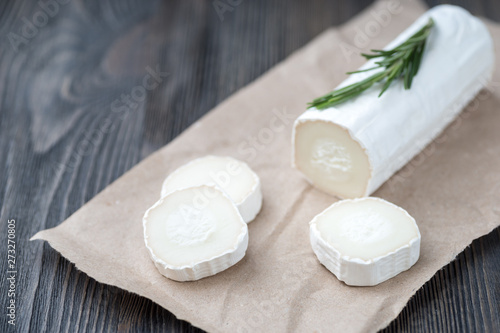 Fresh goat cheese with slices on paper.