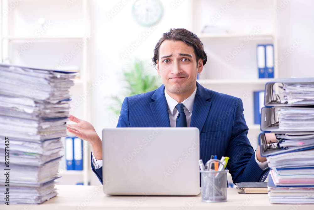 Young male employee unhappy with excessive work Young male employee unhappy with excessive work