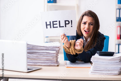 Young beautiful employee tied up with rope in the office 