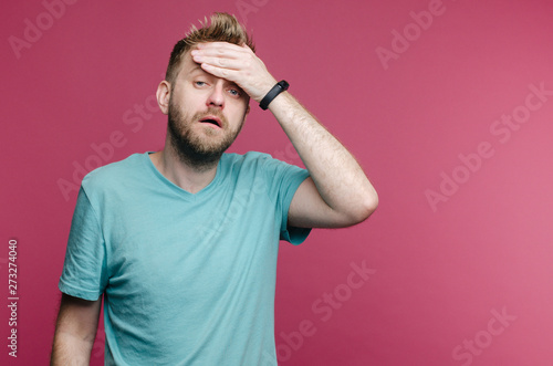 studio picture from a young man suffering from a headache due to a cold or hangover