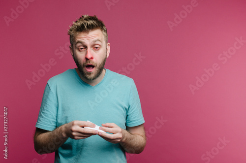 studio picture from a young man with handkerchief going to sneeze. Sick guy isolated has runny nose. man makes a cure for the common cold photo