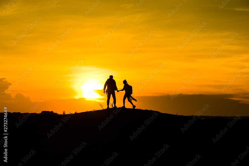 Silhouette couple on the mound in the sunset sky