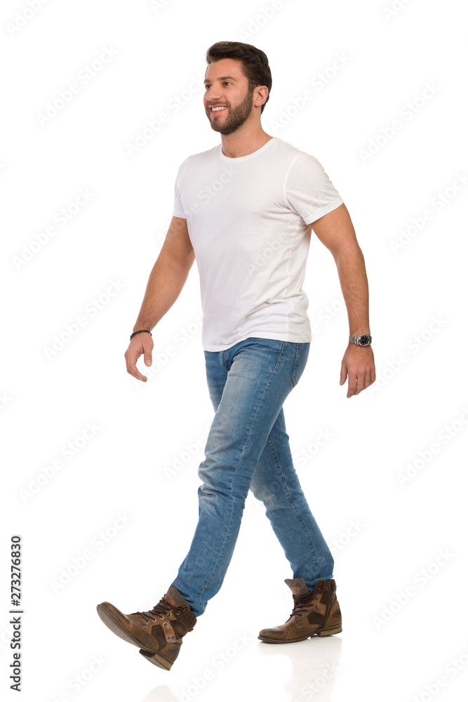 Smiling And Walking Man In White T-shirt, Jeans And Boots Stock Photo |  Adobe Stock