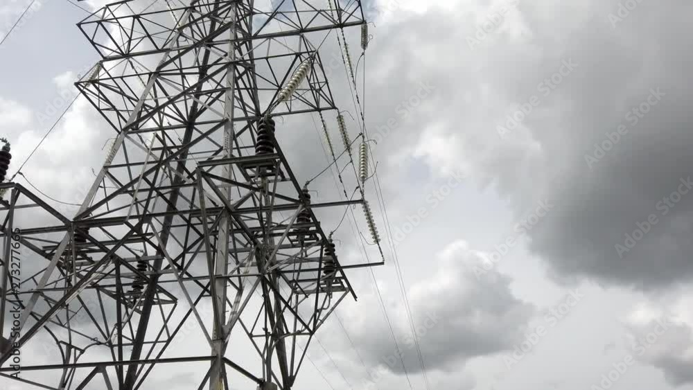 Electricity pylon tower steel structure pull back away to wider view of overcast cloudy sky. Electricity pylon tower steel structure pull back away to wider view of overcast cloudy sky.