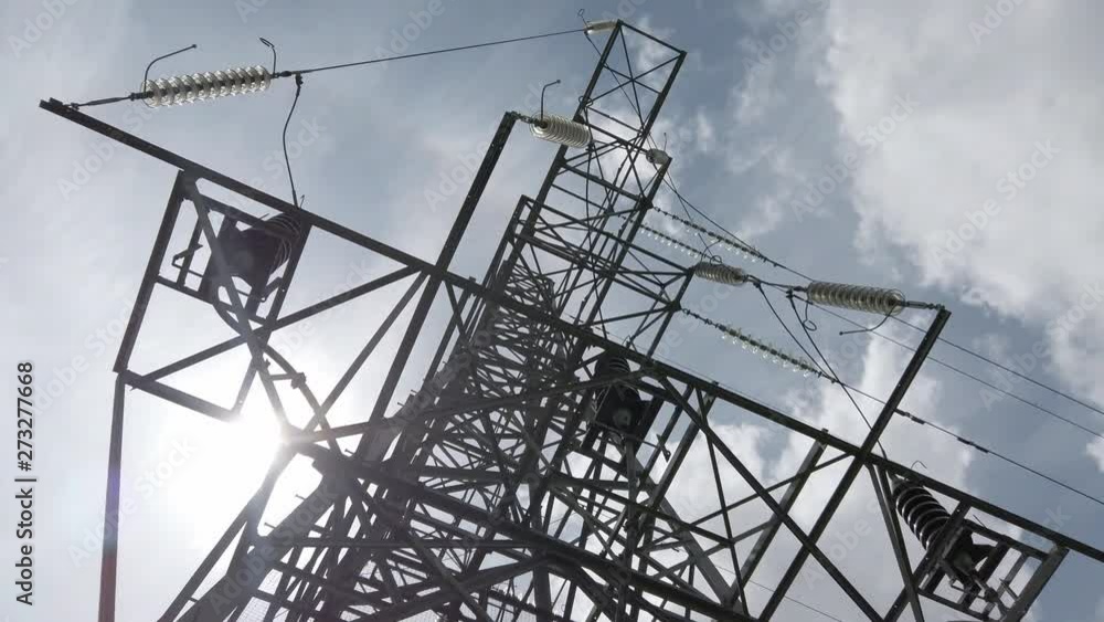 Electricity pylon tower steel structure low angle. Sunlight passing behind metal framework. Electricity pylon tower steel structure low angle. Sunlight passing behind metal framework.