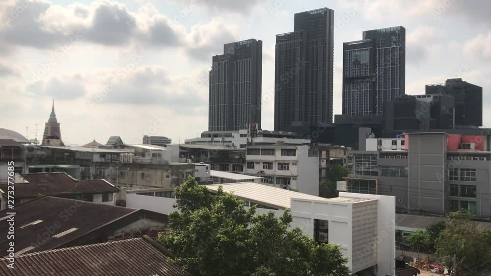 Locked shot of Bangkok City skyline. Punnawithi area with high rise bulidings and poor tin roofed huts in the foreground as a contrast of rich and poor. copy space and background Locked shot of Bangkok City skyline. Punnawithi area with high rise bulidings and poor tin roofed huts in the foreground as a contrast of rich and poor. copy space and background