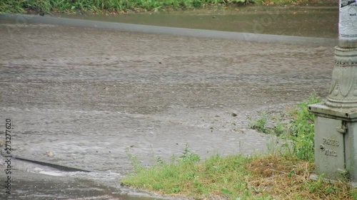 A strong stream of water directly on a city street after a heavy downpour. Elements and bad weather. Hurricane in the city. photo