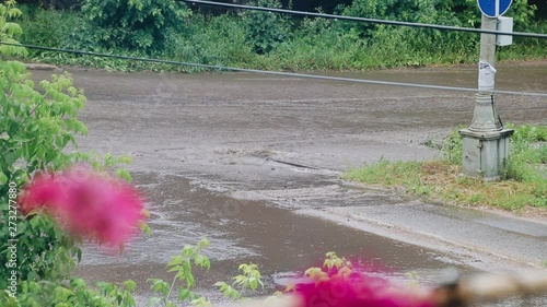 Streams of water flow through the streets of the city after the hurricane. Cars go straight on the water. Heavy rain in the city. photo