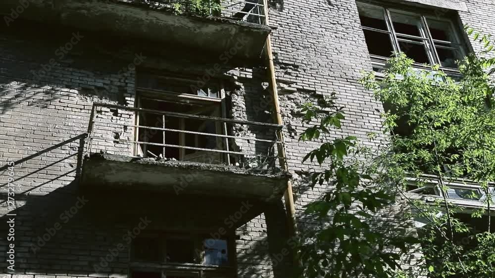 The facade of the old destroyed brick building with broken windows in ...