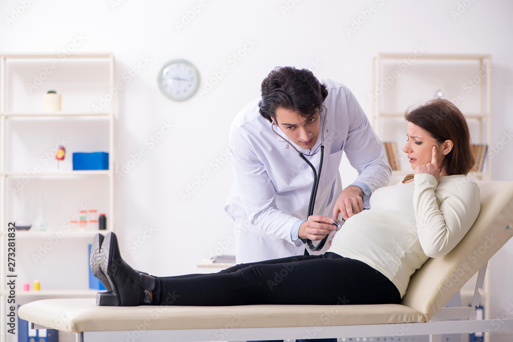 Fototapeta premium Old pregnant woman visiting young male doctor 
