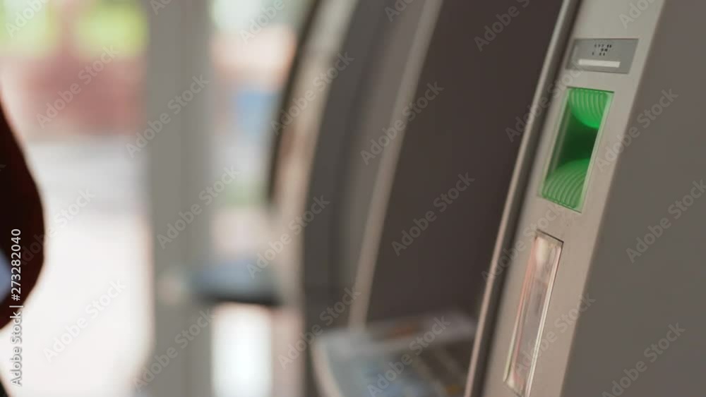 Close-up of african american black man's hand removing a credit card from a cash dispenser. Young man using an ATM machine inside the bank. Close-up of african american black man's hand removing a credit card from a cash dispenser. Young man using an ATM machine inside the bank.