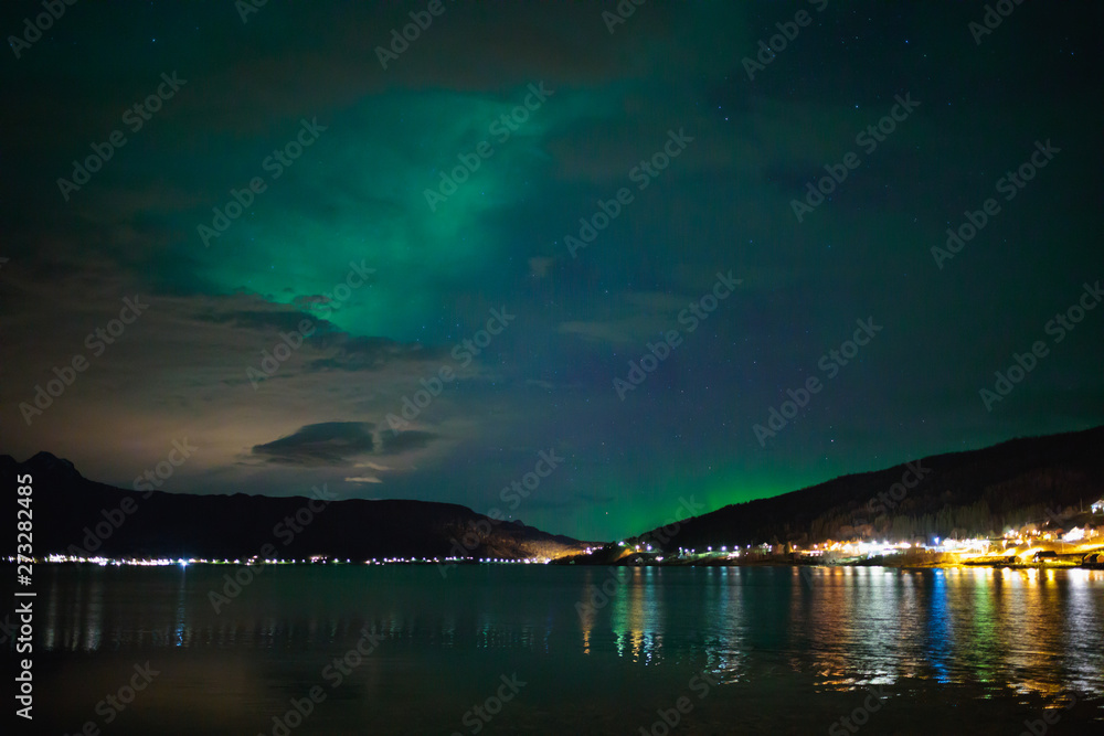 Aurora Borealis over Fjord Gratangen at Årstein in early winter on cloudy day, Nothern lights