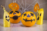 Jack lantern for Halloween of oranges on a wooden background with cobwebs.