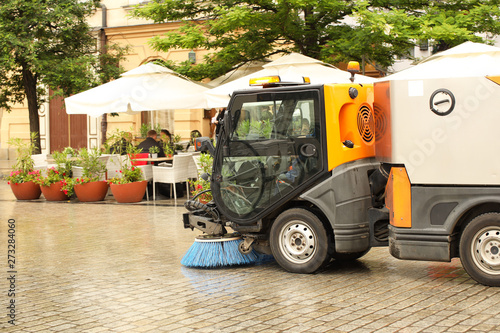 Cuadro en lienzo A street sweeper sweeps up a stone pavement with a strong brush in rainy weather