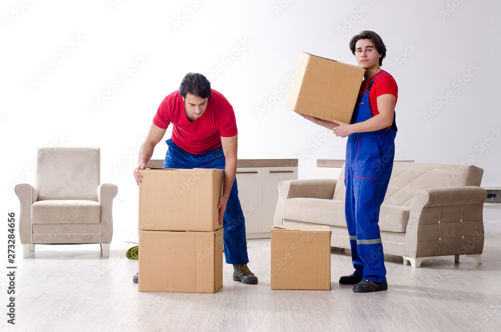 Two young contractor employees moving personal belongings Two young contractor employees moving personal belongings
