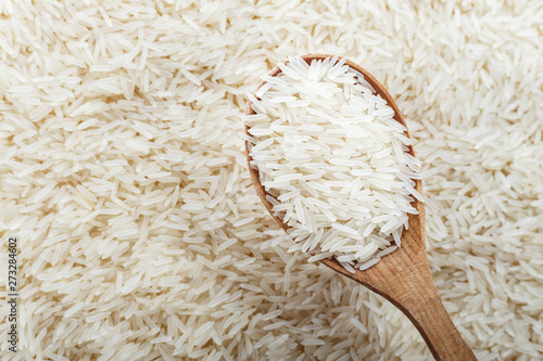 food background. white rice in a wooden spoon.