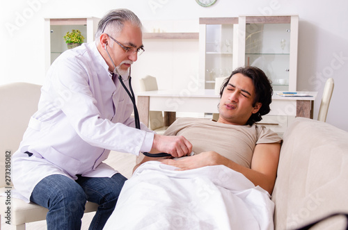 Old male doctor visiting young male patient 