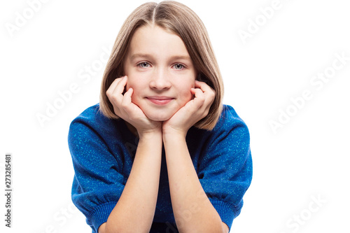 Cute teen girl in a blue sweater smiles. Close-up. Isolated on a white background.