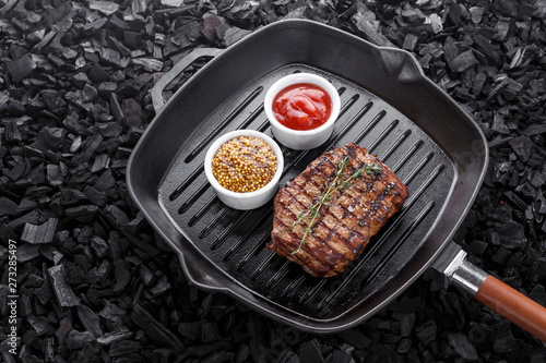 Grilled steak cooked in a frying pan.