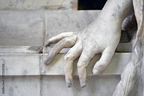 Partial view of a white sandstone sculpture whose hand was placed on a table.  © Frank Middendorf