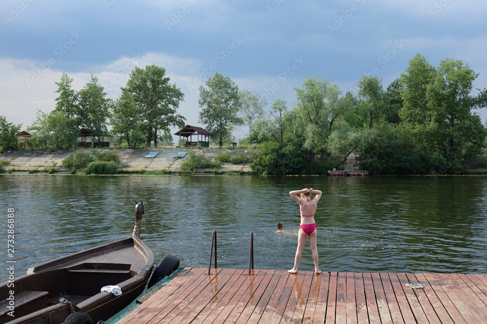 Fototapeta premium mała dziewczynka skacze z molo nad rzeką