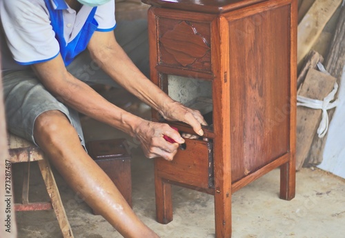 Carpenter repairing wooden drawers Three floors, small, new furniture, red wood, old Thai, polished, background color, people working with hands, conserving crafts