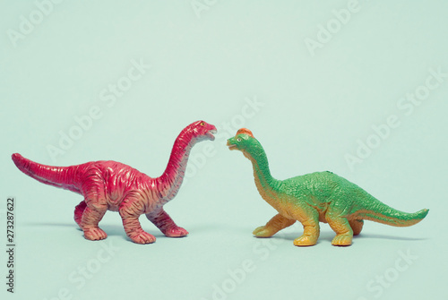 two plastic dinosaurs facing each other